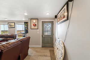 Foyer with light wood finished floors and a textured ceiling