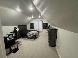Bedroom featuring a textured ceiling and light carpet
