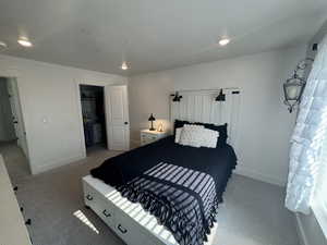 Bedroom with carpet floors, recessed lighting, and a walk in closet