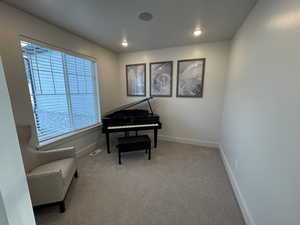 Living area featuring light colored carpet and recessed lighting