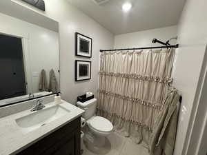 Full bathroom with vanity, a shower with shower curtain, light tile patterned floors, and a textured ceiling