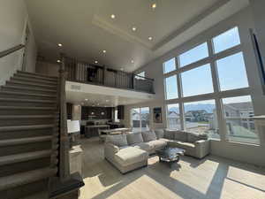 Living area with recessed lighting, light wood finished floors, a high ceiling, and a residential view