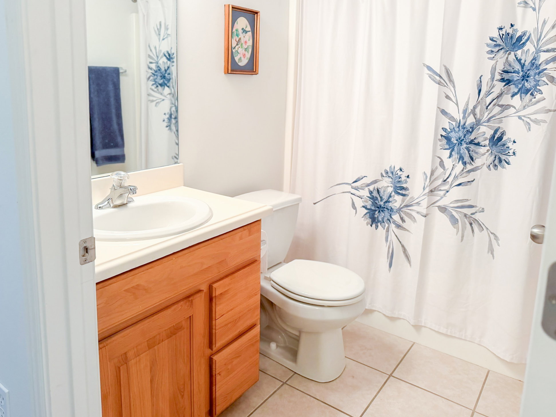 Full bath with vanity, light tile patterned floors, and a shower with shower curtain