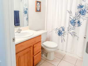 Full bath with vanity, light tile patterned floors, and a shower with shower curtain
