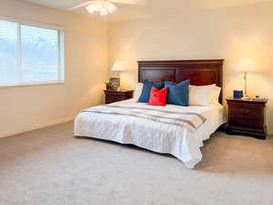 Bedroom with ceiling fan and light carpet
