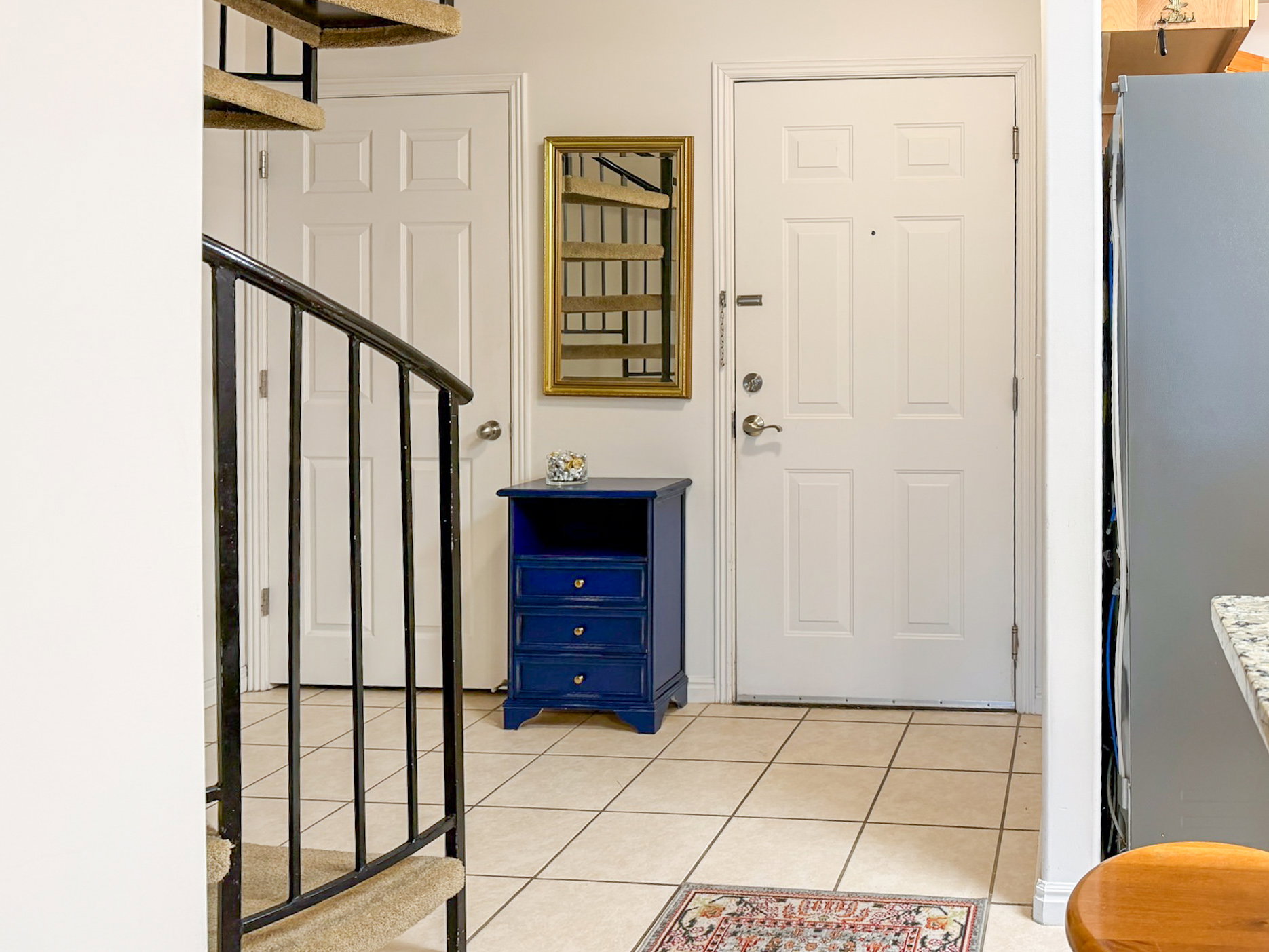 Entrance foyer with stairway and light tile patterned floors