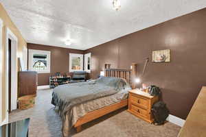 Bedroom with light carpet and a textured ceiling