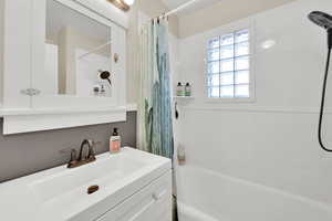 Bathroom featuring shower / bath combination with curtain and vanity