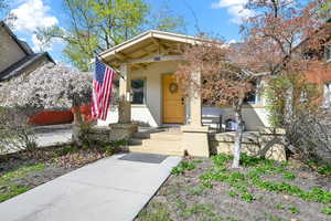 View of exterior entry with a porch and stucco siding