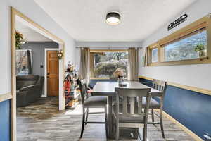Dining room with light wood finished floors and a textured ceiling