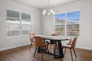 Dining area featuring dark wood-style floors and suspended lighting