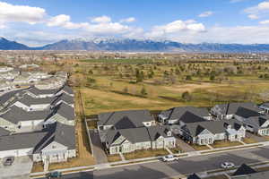 Aerial view of residential area with a mountain backdrop and a golf club