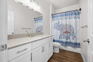 Bathroom with vanity, dark wood-type flooring, and shower / tub combo with curtain