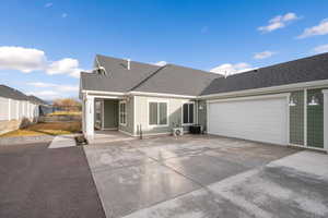 View of front facade with roof with shingles, concrete driveway, and an attached garage