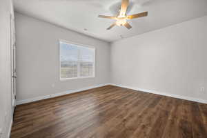 Spare room with a ceiling fan and dark wood-type flooring