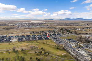 Aerial perspective of suburban area featuring a golf club and mountains