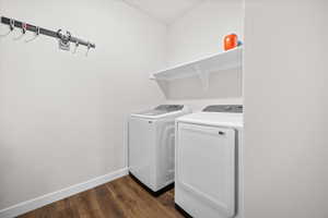 Laundry area featuring dark wood-style flooring and washing machine and clothes dryer