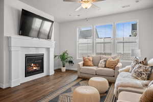 Living area featuring ceiling fan, wood finished floors, and a fireplace