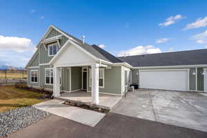 View of front of house with board and batten siding, concrete driveway, a shingled roof, and an attached garage
