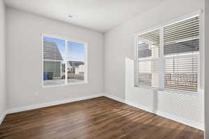 Unfurnished room with dark wood-style flooring and baseboards