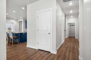 Hall with dark wood finished floors and recessed lighting