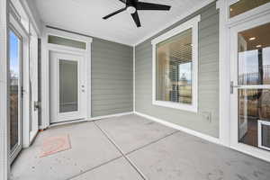 Unfurnished sunroom with a patio and ceiling fan