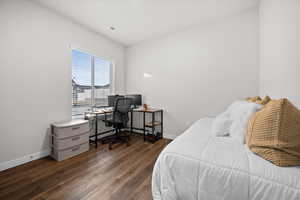 Bedroom with an office area and dark wood finished floors