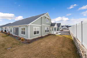 Back of house featuring a patio area and roof with shingles