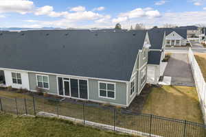 Back of property featuring a fenced backyard, a shingled roof, and a residential view