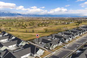 Aerial perspective of suburban area featuring a mountainous background and a golf club