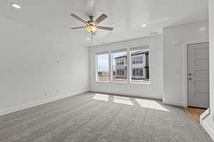 Unfurnished room with light colored carpet, ceiling fan, and recessed lighting