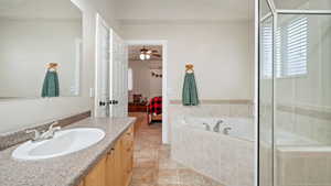 Bathroom featuring vanity, ensuite bath, a stall shower, light tile patterned floors, and plenty of natural light