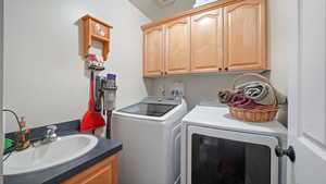 Laundry room featuring a sink and separate washer and dryer
