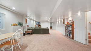 Living room with light carpet, recessed lighting, and a textured ceiling