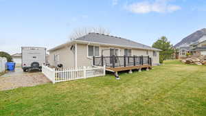 Rear view of house featuring a deck and roof with shingles