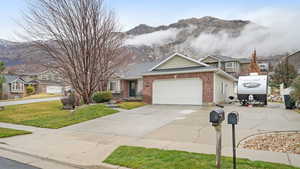 View of front of property featuring a mountain view, an attached garage, and driveway