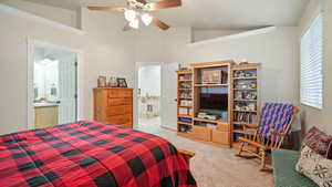 Bedroom with vaulted ceiling, light carpet, and ceiling fan