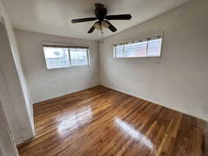 Empty room with wood-type flooring, a ceiling fan, and vaulted ceiling