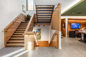 Staircase featuring wooden walls and baseboards