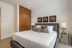Bedroom with light carpet, a closet, and recessed lighting