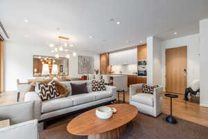 Living area with hanging lights and light wood finished floors