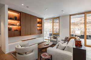 Living area featuring light wood-style flooring, expansive windows, and recessed lighting
