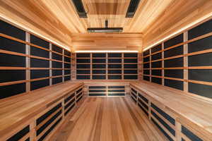 Relaxing sauna with hardwood / wood-style flooring and wood ceiling
