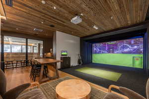 Rec room featuring golf simulator, wood ceiling, and wood finished floors