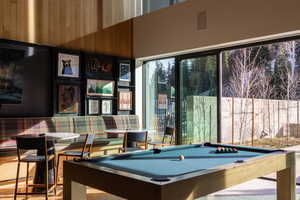 Game room featuring billiards table, a high ceiling, and wood walls