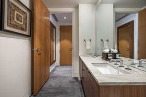 Bathroom featuring double vanity, concrete floors, and recessed lighting