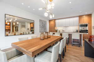 Dining room with hanging lights and light wood-style flooring