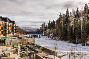View of community with a mountain view, a patio area, and an outdoor living space with a fire pit