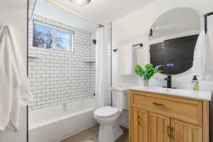 Full bath featuring vanity, shower / bath combo with shower curtain, and a textured ceiling