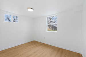 Empty room with light wood-type flooring and healthy amount of natural light